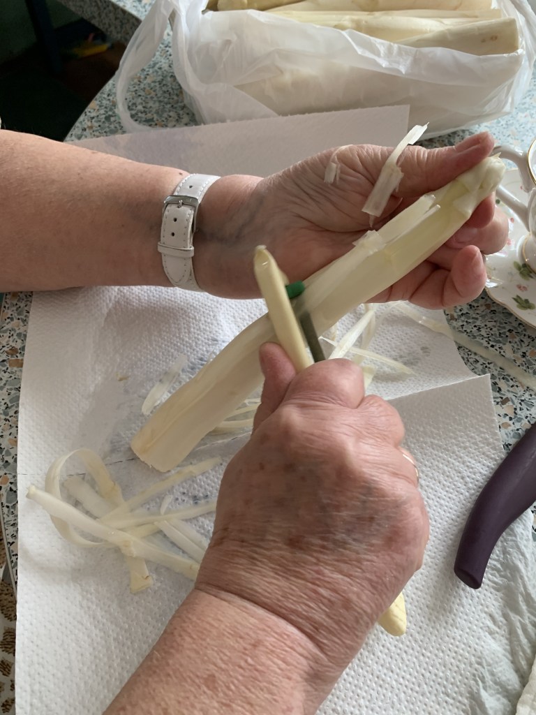My Oma peeling asparagus, removing the tough, bitter outer layer of the spears.